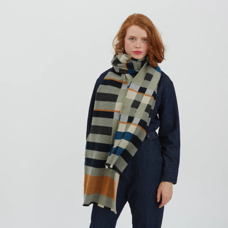 The 100% lambswool Stölzl Wrap from Wallace & Sewell in the orchard pattern being modeled in a lifestyle photograph.