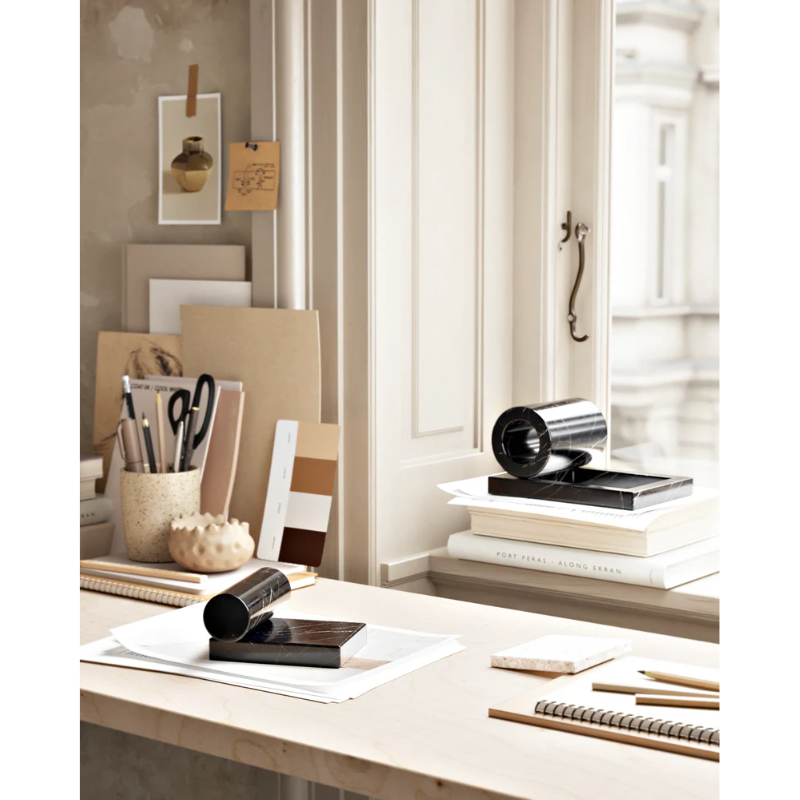 The Booknd from Woud, a solid marble bookend, being used as paper weights in an office space.