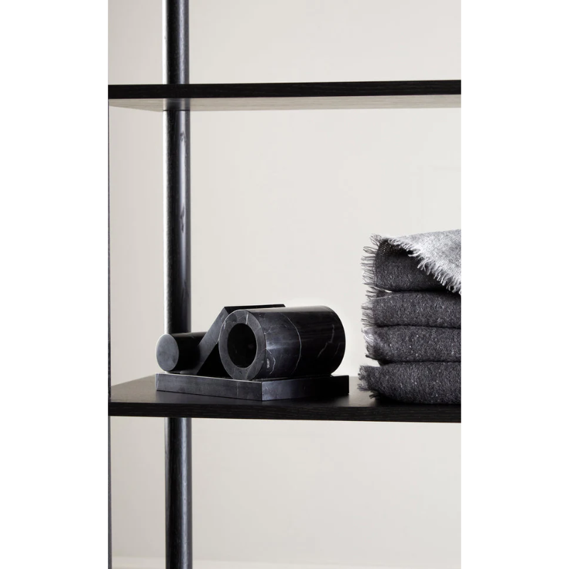 The Booknd from Woud, a solid marble bookend, stacked together on a shelf.