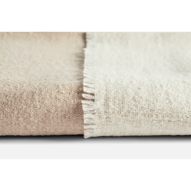 This is a detailed close up on the fabric quality of the merino wool used in the Double Throw from Woud. The color choice shown is the beige and off white color.