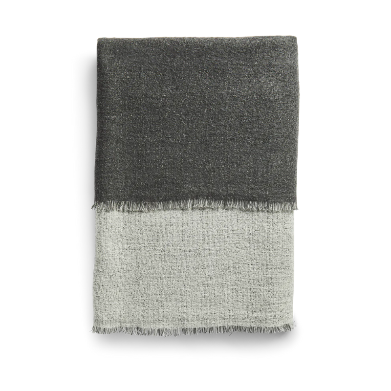 This is the Double Throw from Woud which is made out of 100% merino wool. The color pattern for this throw is light grey and dark grey.