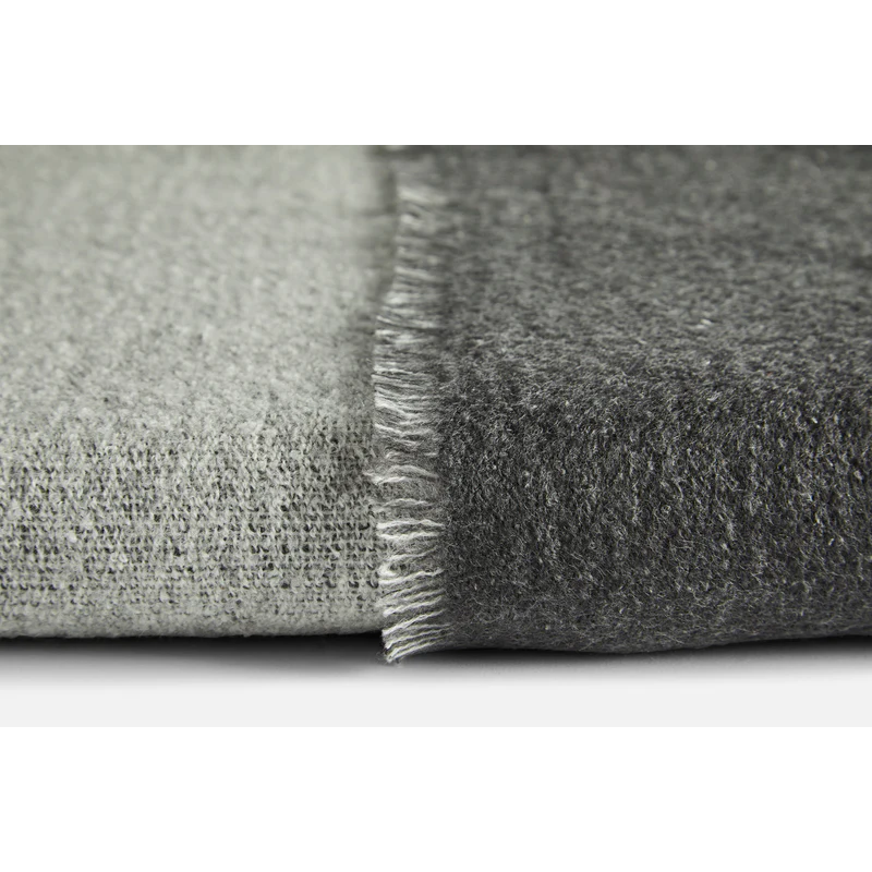 This is a detailed close up on the fabric quality of the merino wool used in the Double Throw from Woud. The color choice shown is the light grey and dark grey color.