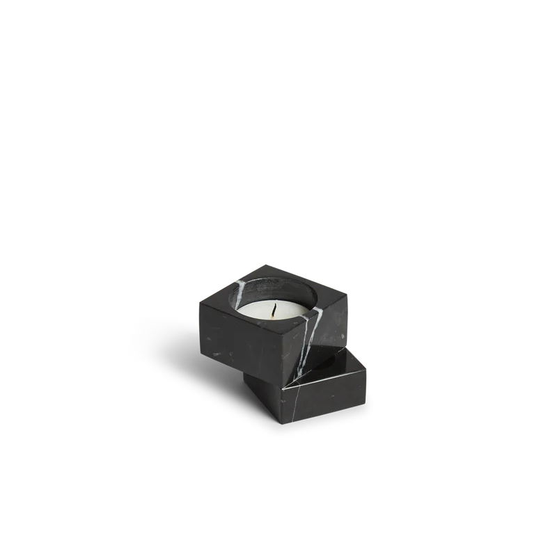 The solid marble Jeu De Dés 1 Candle Holder from Woud with a tea light in black.