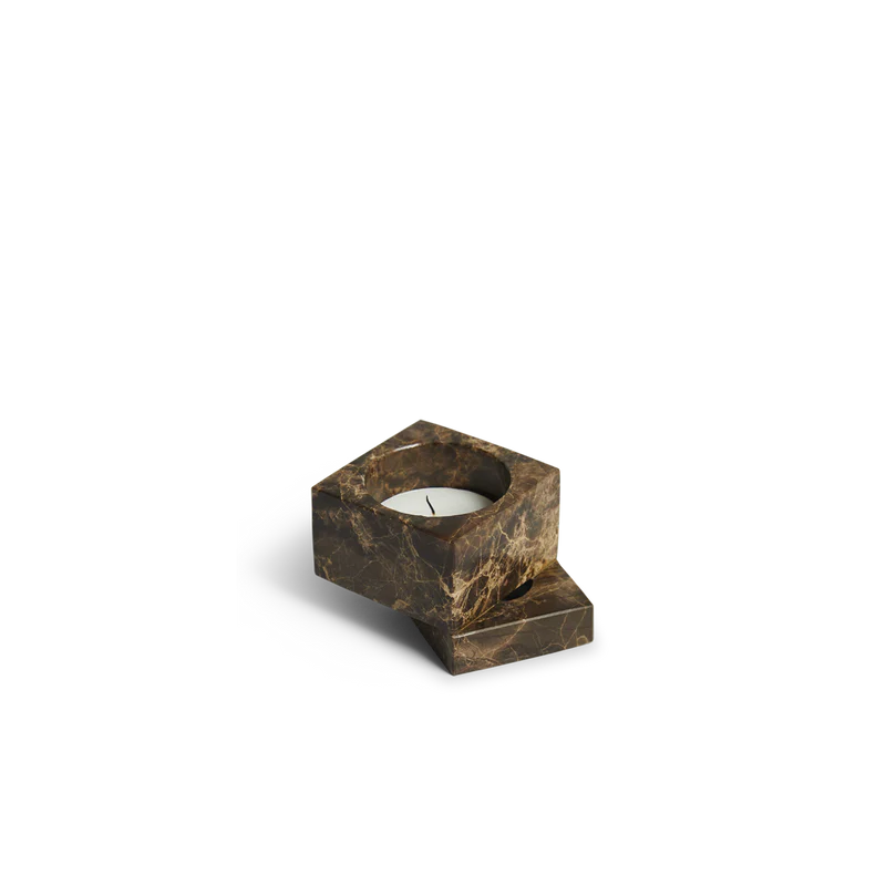 The solid marble Jeu De Dés 1 Candle Holder from Woud with a tea light in brown.