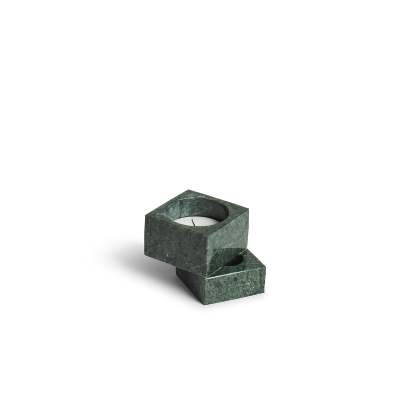 The solid marble Jeu De Dés 1 Candle Holder from Woud with a tea light in green.