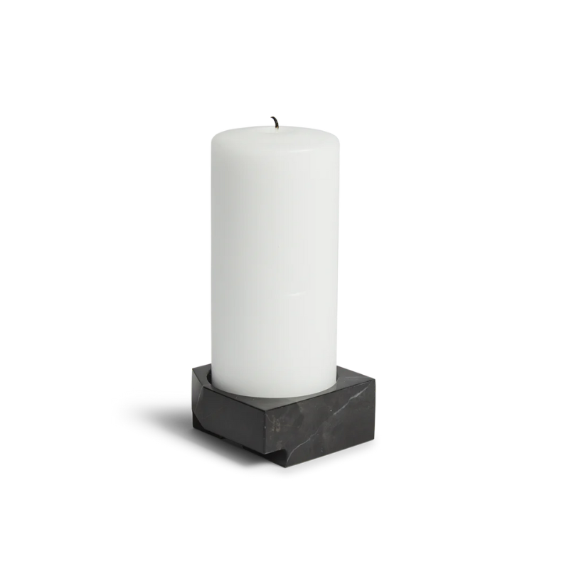 The Jeu De Dés 3 Candle Holder from Woud, made from solid marble with a pillar candle, in black.