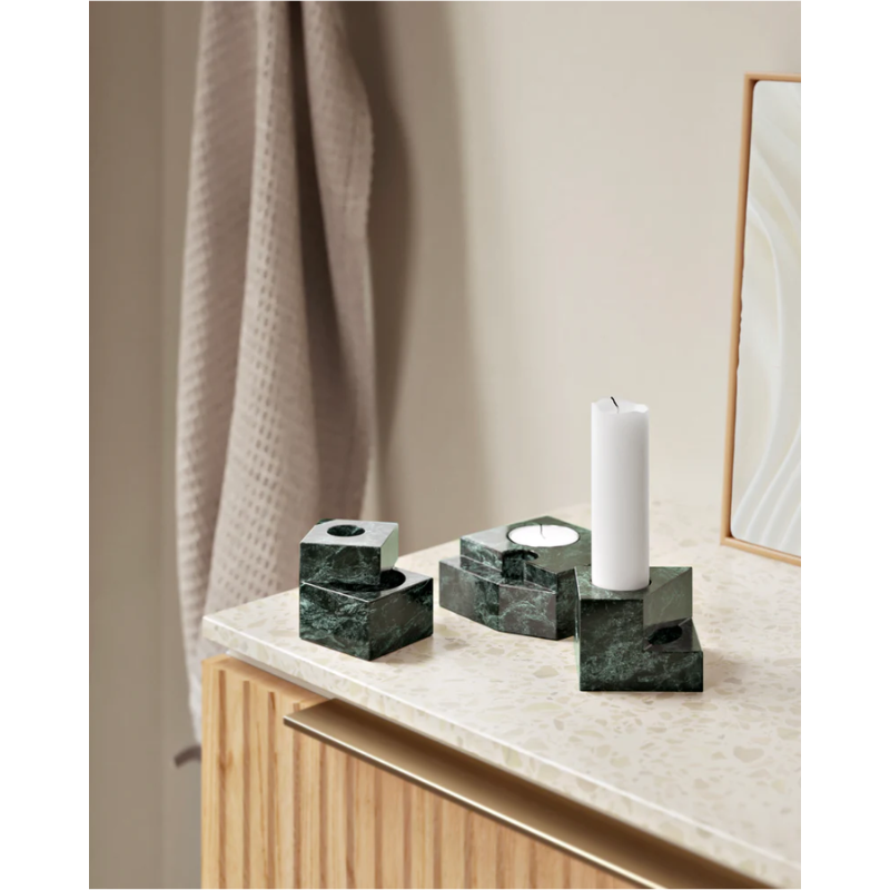 The Jeu De Dés 1, 2 and 3 Candle Holder from Woud, made from solid marble in green featured on a bathroom countertop.