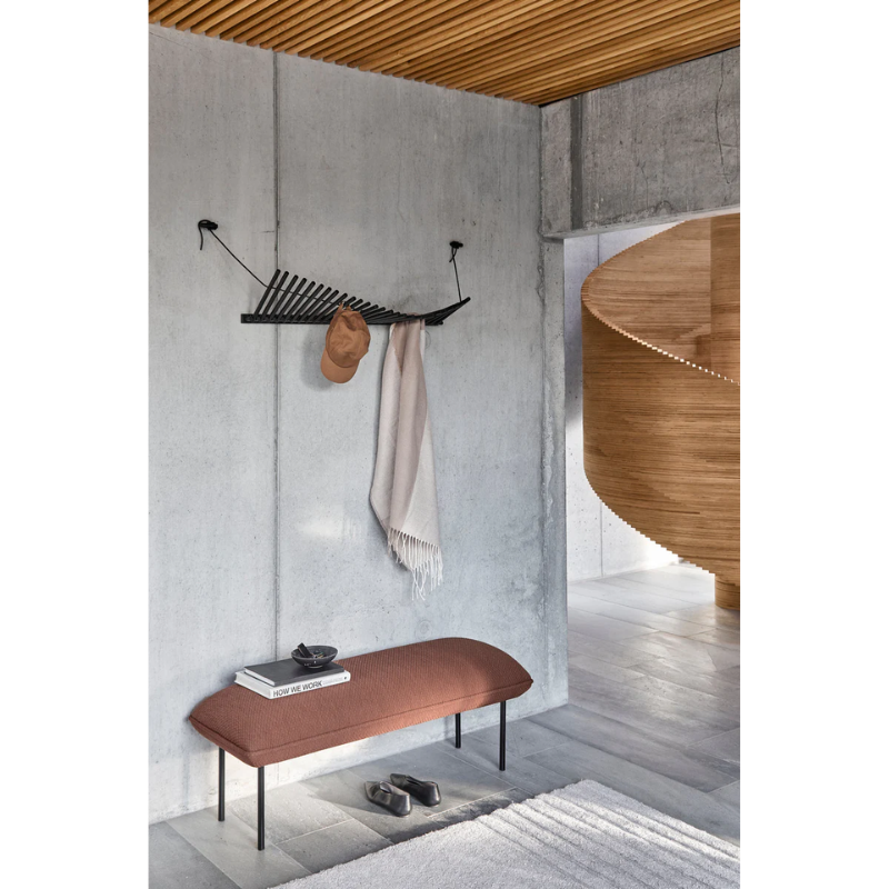 The Knaegt Coat Rack from Woud in black being used in a hallway.
