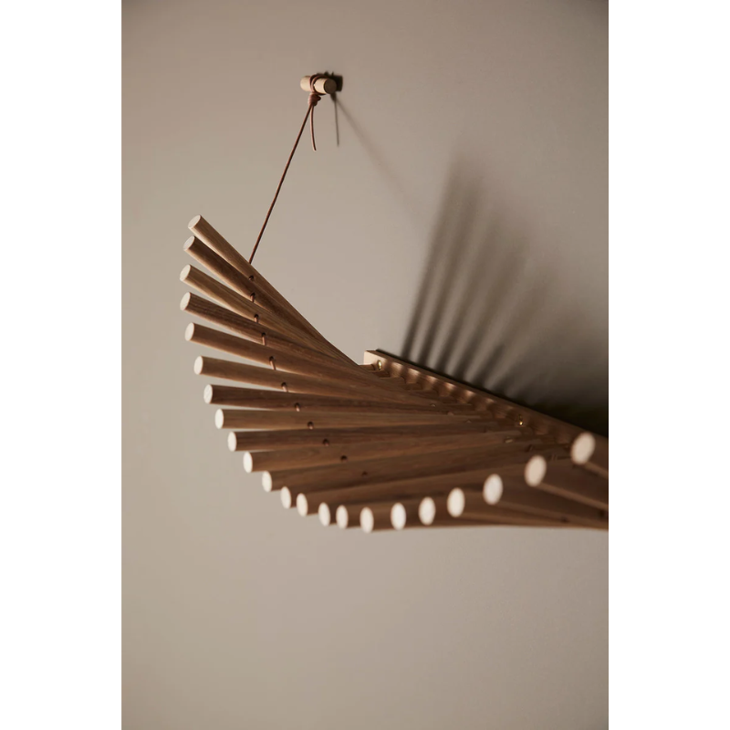 The Knaegt Coat Rack from Woud in white pigmented oak with a close up shot showing the shadow the rack casts on the wall when lit.
