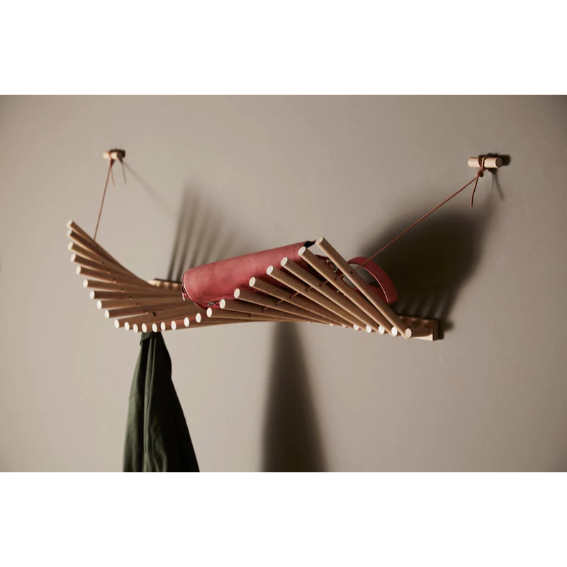 The Knaegt Coat Rack from Woud being used within a family space, holding a bag and a coat.