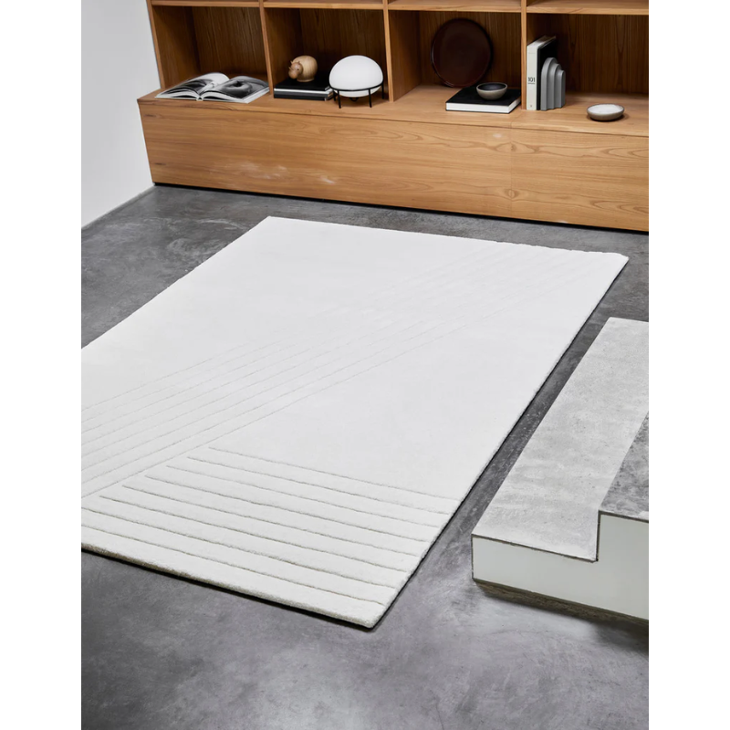 The Kyoto Rug from Woud in a family area with other Woud products such as the Arkiv Bookend and Hibo Hippopotamus in the background.