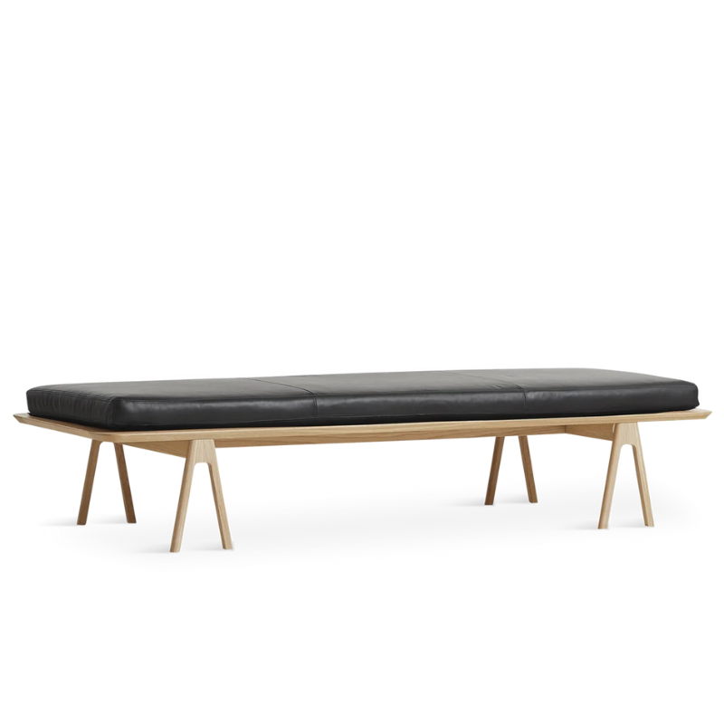 The Level Daybed from Woud with black leather cushion and oak frame.