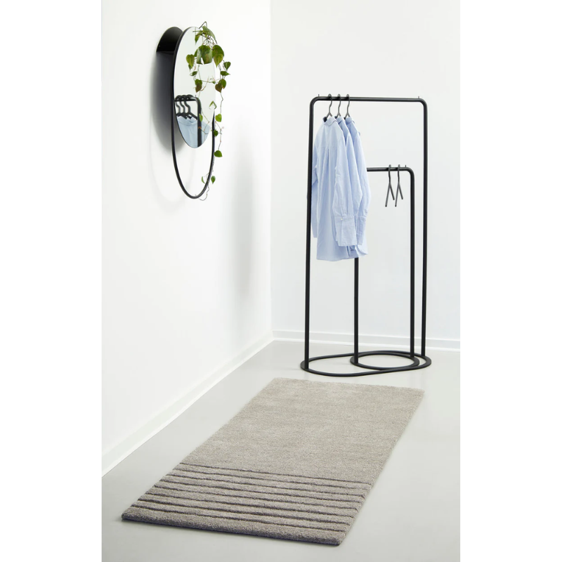 The small O&O Clothes Rack inside of the large O&O Clothes Rack from Woud with the Illusion Hangers within a bedroom.