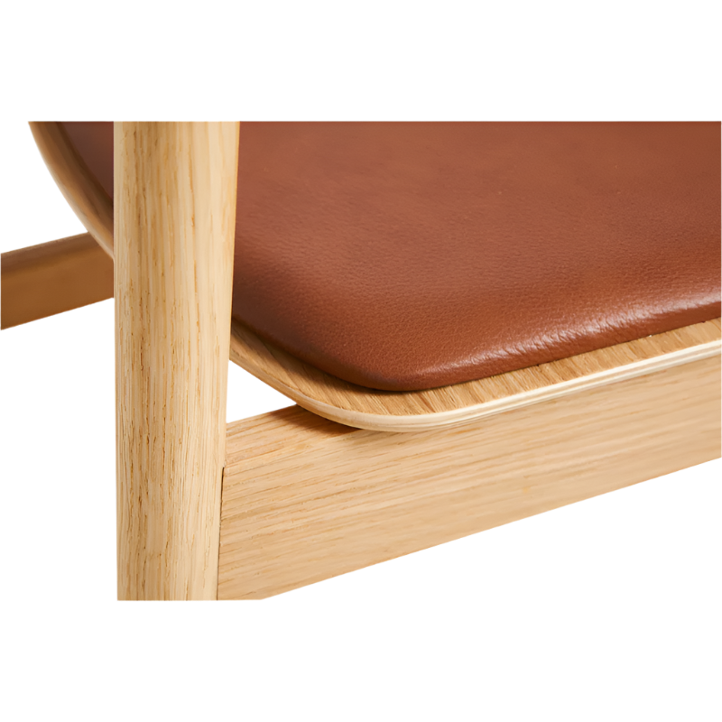 A close up on the Pause Dining Chair 2.0 from Woud in Oiled Oak with Leather.