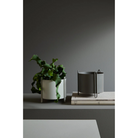 The grey and taupe Pidestall Planters from Woud side by side.