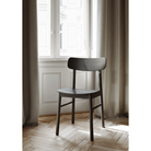 The Soma Dining Chair from Woud in Black within a living room.