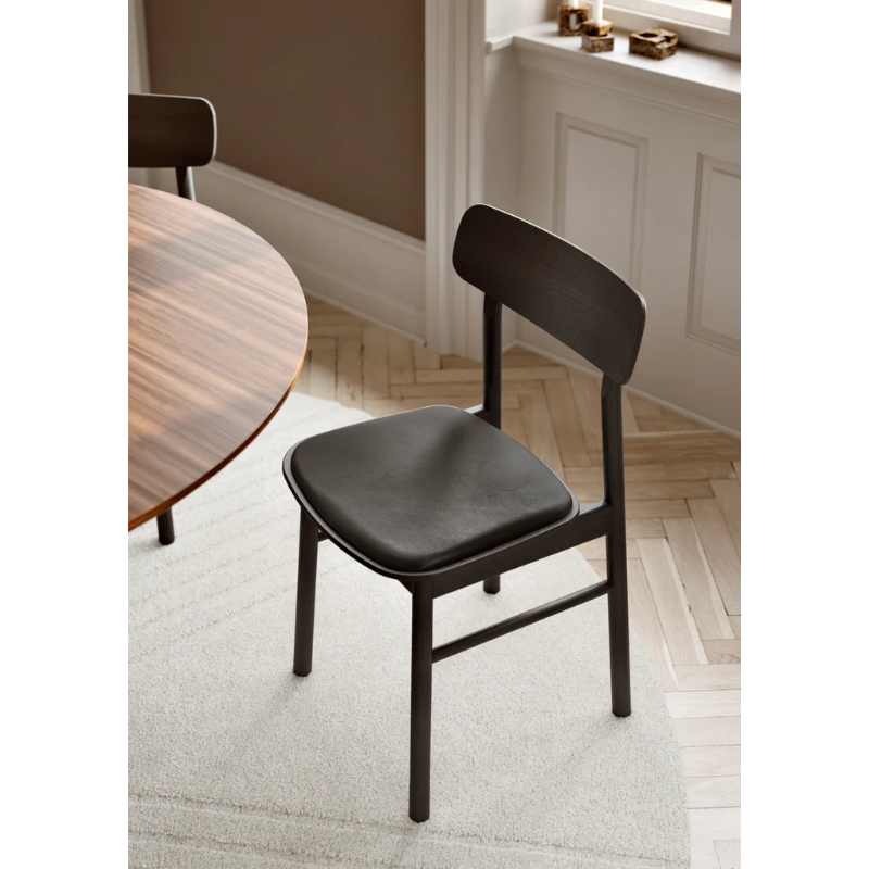 The Soma Dining Chair from Woud in Black with Leather with a detailed shot in a dining room.