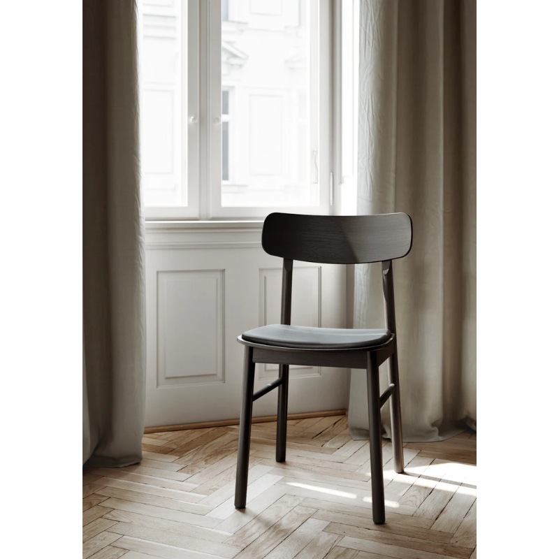 The Soma Dining Chair from Woud in Black with Leather within a lounge.