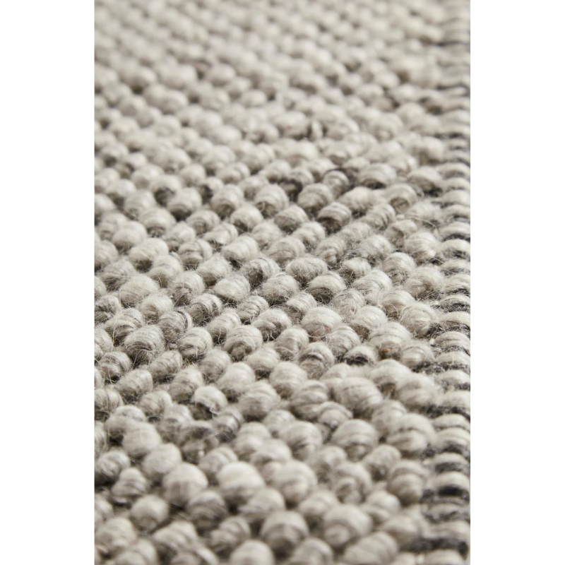 A close up on the fabric used for the Tact Rug from Woud in dark grey color.