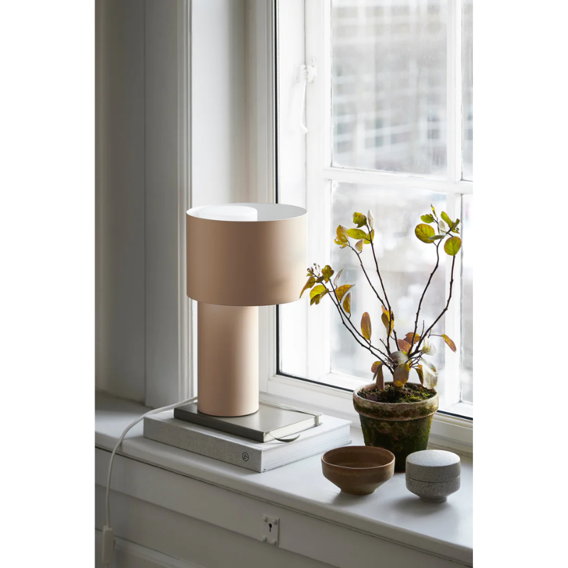 The Tangent Table Lamp from Woud on a window ledge.