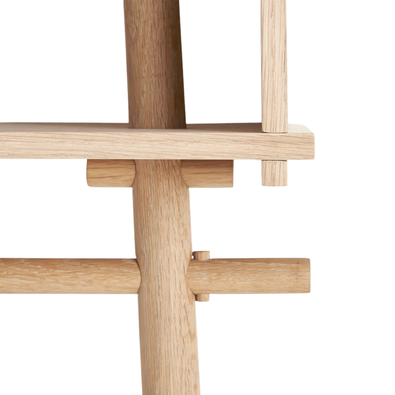 A detailed shot on the corner of the Töjbox Wardrobe from Woud in white pigmented oak color.