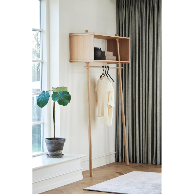 The Töjbox Wardrobe in a living room next to a house plant.