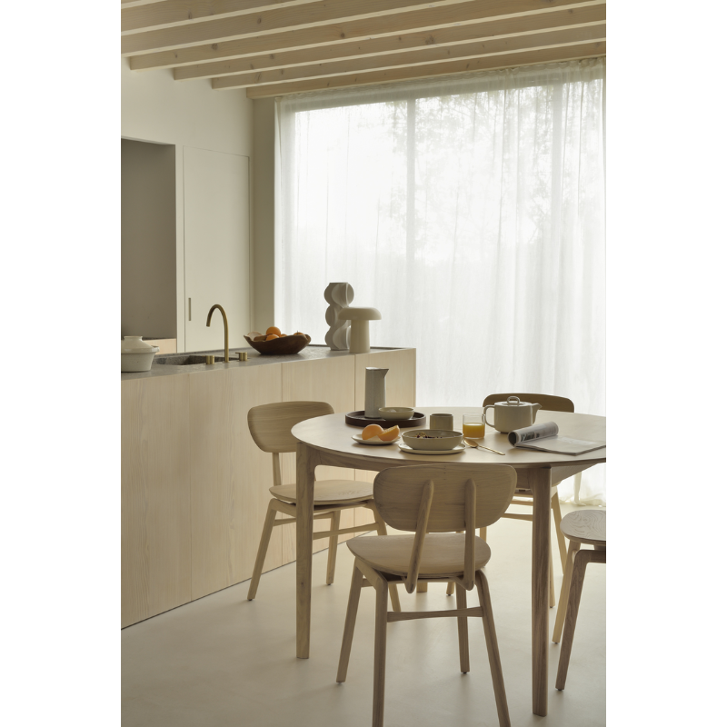 The Round Bok Extendable Dining Table from Ethnicraft in a dining room.