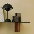 &Tradition VP9 Flowerpot Portable Table Lamp in matte black on a shelf with no power supply.