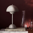 &Tradition VP9 Flowerpot Portable Table Lamp in matte grey on shelf.
