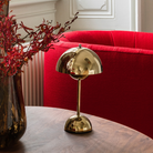 &Tradition VP9 Flowerpot Portable Table Lamp in brass plated in a living room.