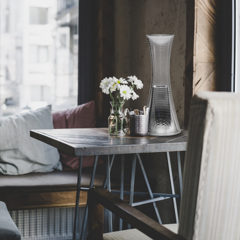 The Come Together Portable Lamp from Artemide in aluminum in a dining room.