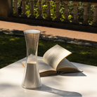 The Come Together Portable Lamp from Artemide in white in an outdoor living area.