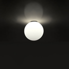 The Dioscuri Wall / Ceiling Light from Artemide in the size medium turned on installed on the ceiling.