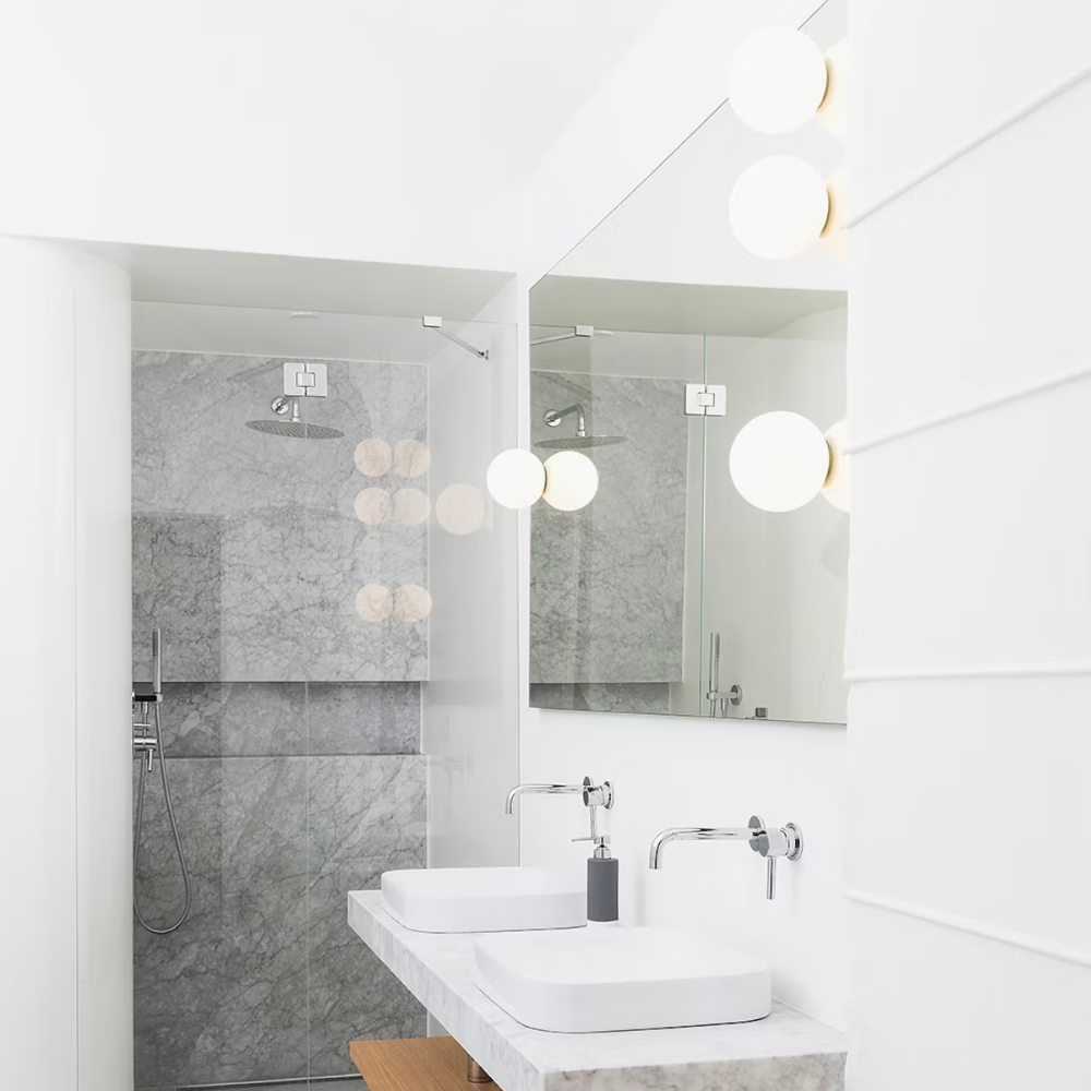 The Dioscuri Wall / Ceiling Light from Artemide in the size small in a bathroom.