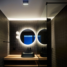 The Dioscuri Wall / Ceiling Light from Artemide in the size small in a bathroom.
