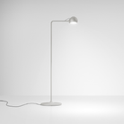 The white Ixa Reading Floor Lamp from Artemide in a living area.