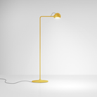 The yellow Ixa Reading Floor Lamp from Artemide in a family room.