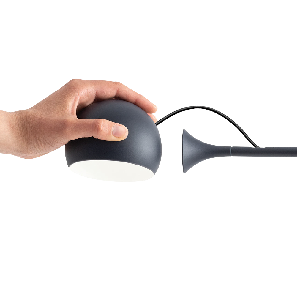 The anthracite gray Ixa Table Lamp from Artemide showing the detachable light.