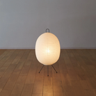 The Tawara A121 by Asano is a small floor lamp made of rice paper. Image of lamp on the floor turned on.