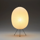 The Tawara A121 by Asano is a small floor lamp made of rice paper. Image of lamp turned on.