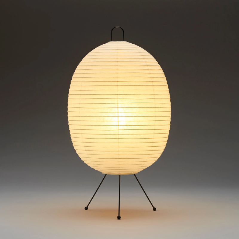 The Tawara A121 by Asano is a small floor lamp made of rice paper. Image of lamp turned on.