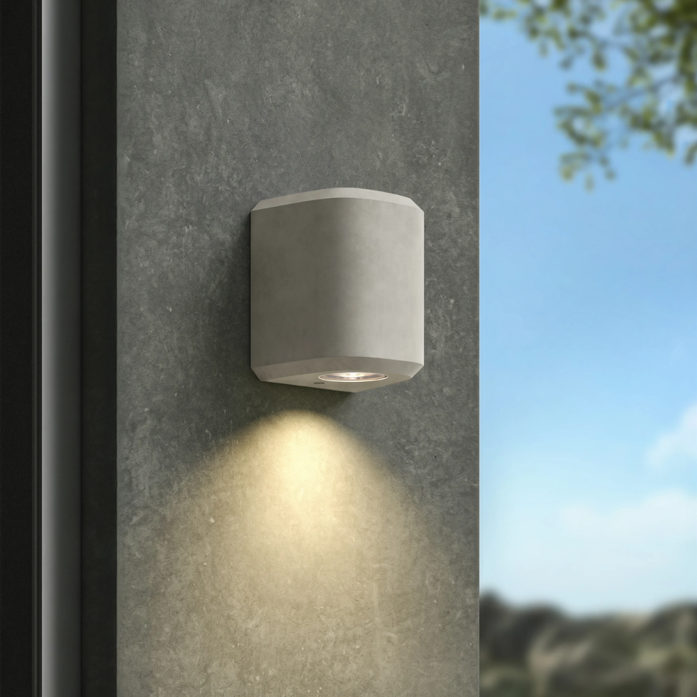 The Brixham Wall Single outdoor sconce in grey concrete by Astro Lighting installed on a concrete wall during the day.