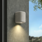 The Brixham Wall Single outdoor sconce in grey concrete by Astro Lighting installed on a concrete wall during the day.