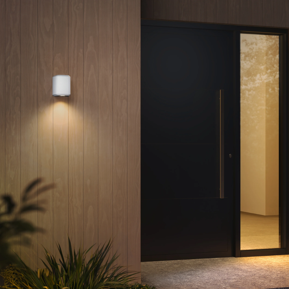 Brixham Wall Single outdoor sconce in white concrete by Astro Lighting installed outside at night.