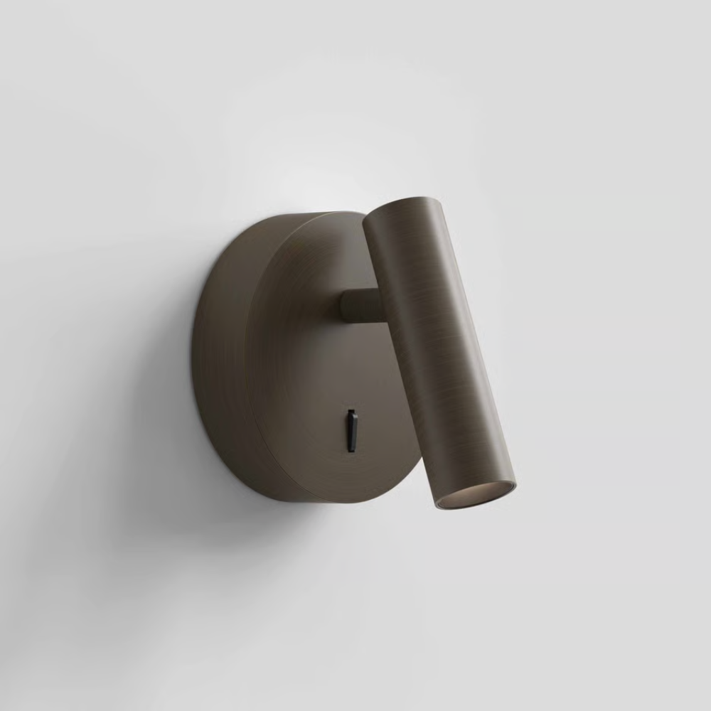 The bronze Enna Surface Round Wall Sconce from Astro Lighting in a primary bedroom.