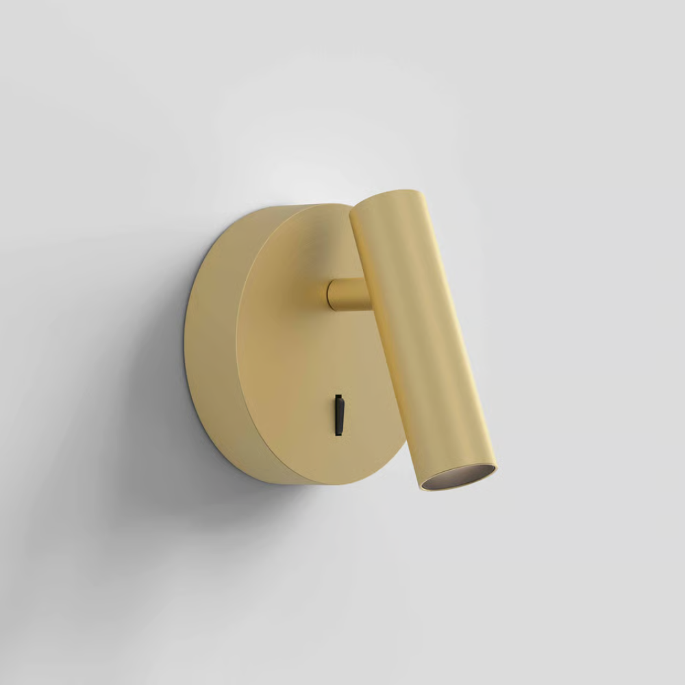 The matte gold Enna Surface Round Wall Sconce from Astro Lighting in a living area.