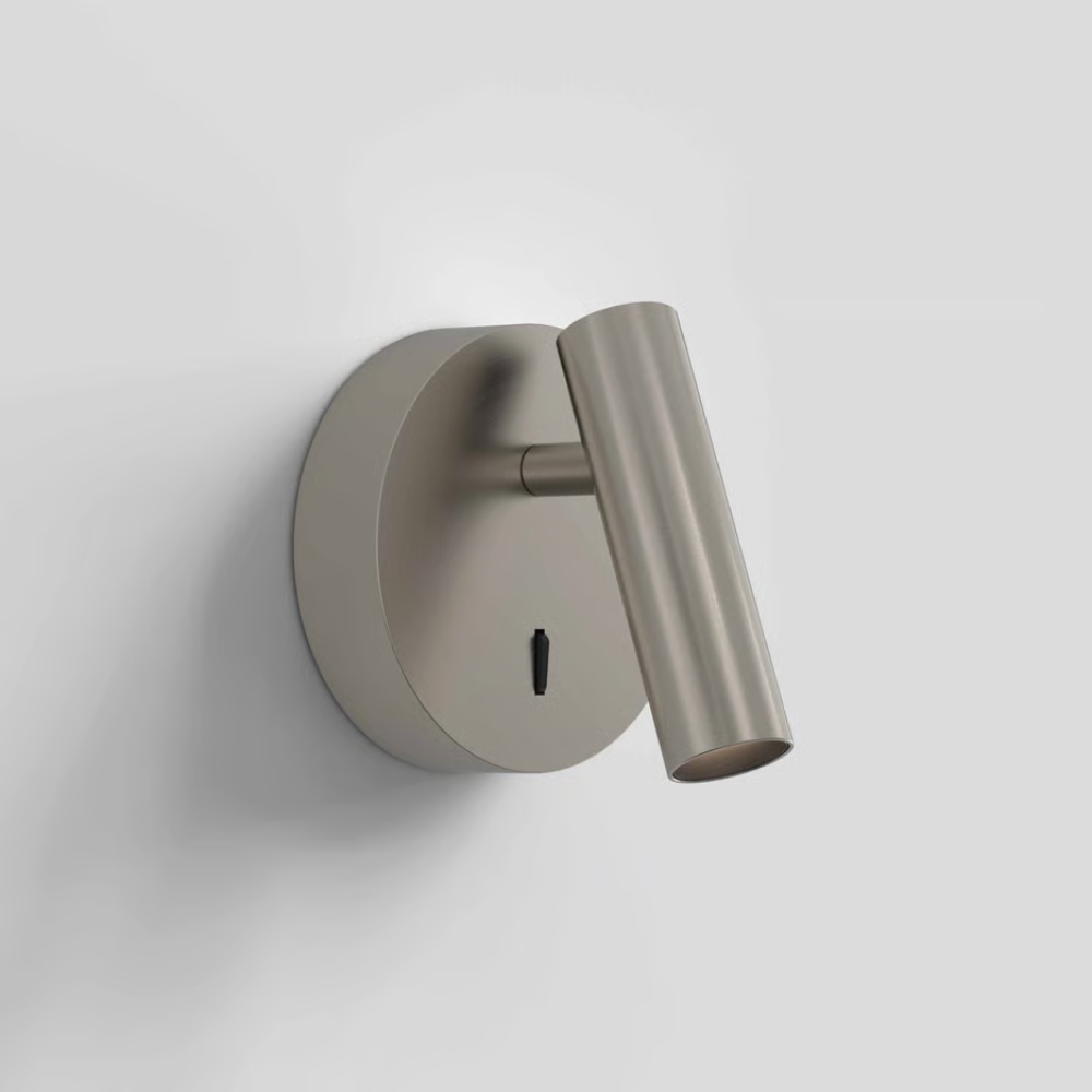 The matte nickel Enna Surface Round Wall Sconce from Astro Lighting in a living room.