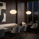 The small Flow Pendant from Astro Lighting with the matte white base in a living room.