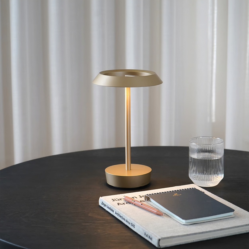 The Halo Portable Lamp from Astro Lighting in light bronze in a dining room.