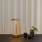 The Halo Portable Lamp from Astro Lighting in light bronze on a dining table in a dining room.